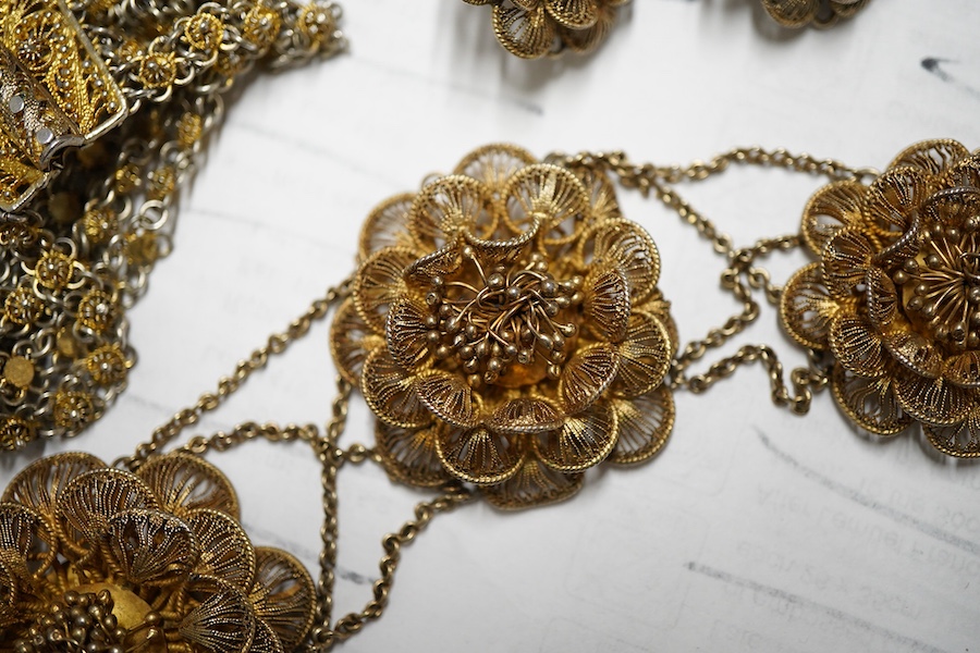 A gilt white metal filigree parure, comprising a necklace, 36cm, with flower head motifs, a pair of flower head earrings and a bracelet.